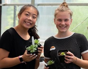 两名学生在技能中心课程上拿着植物