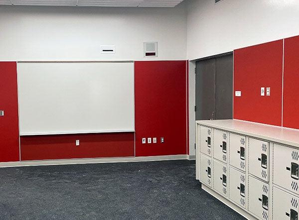 红墙房间里的白板和低矮的储物柜