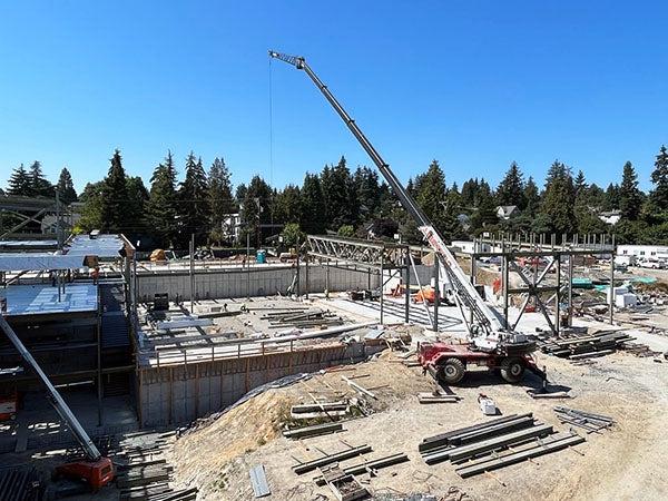 a crane lifting steel beams at a construction site