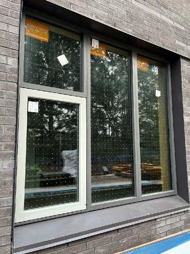 closeup of a window with glass that has dots on it. brick veneer surrounds the window