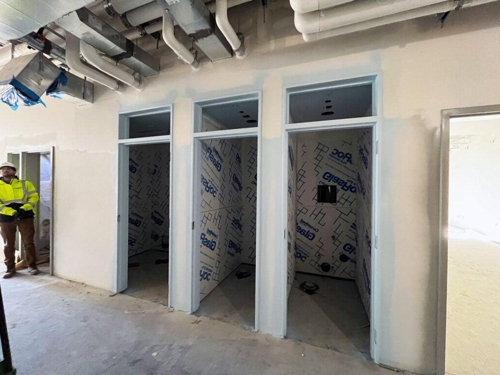 3 closets with walls around them that are partly painted