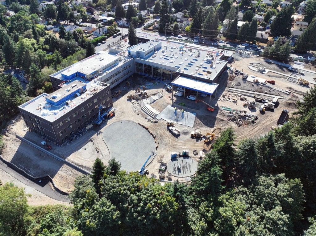aerial view of an L shaped building with construction work happening in the area between them
