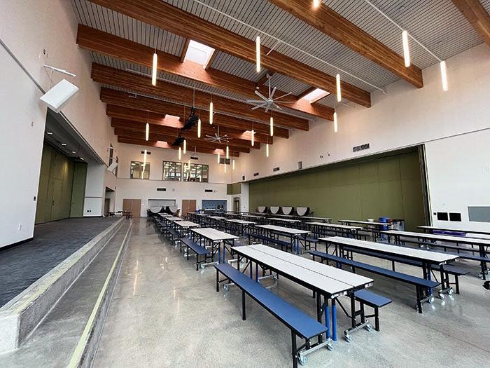 a lunchroom with tables and ceiling fans