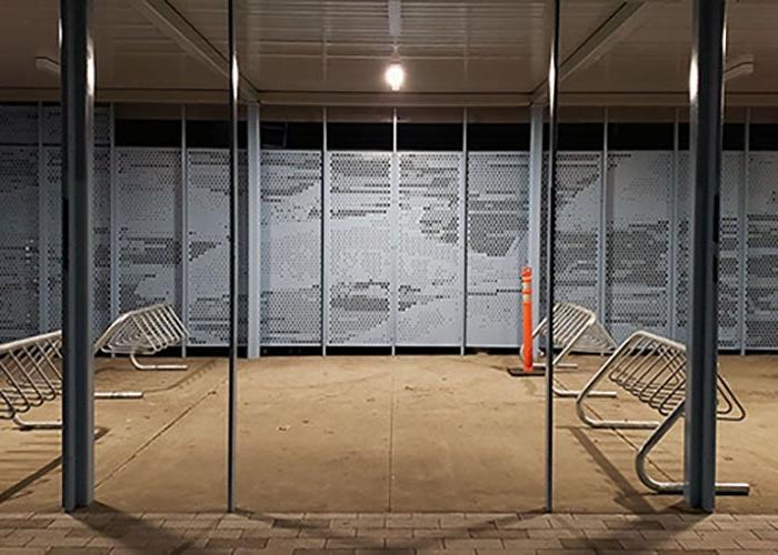 a covered area with bike racks and a perforated metal back wall