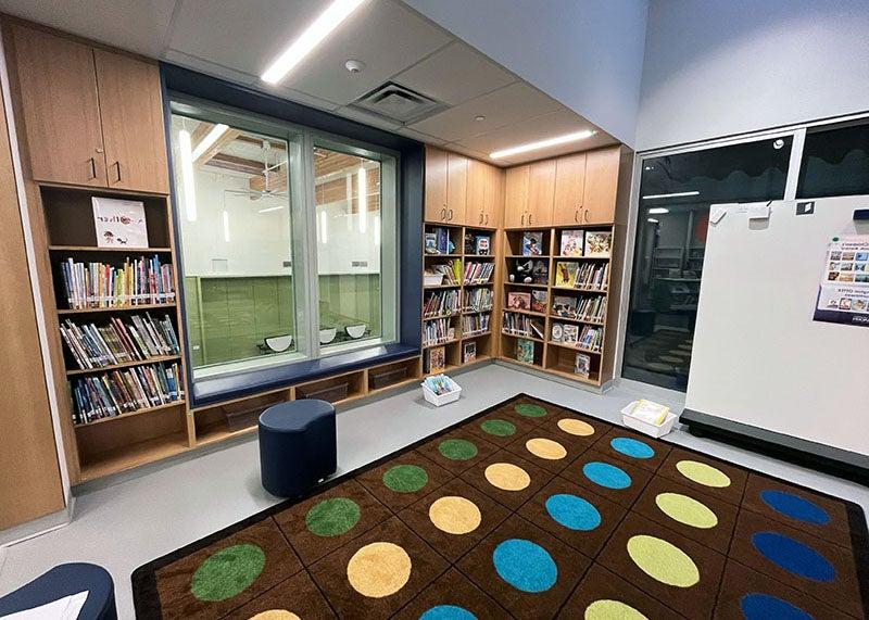 a space with a rug and bookshelves